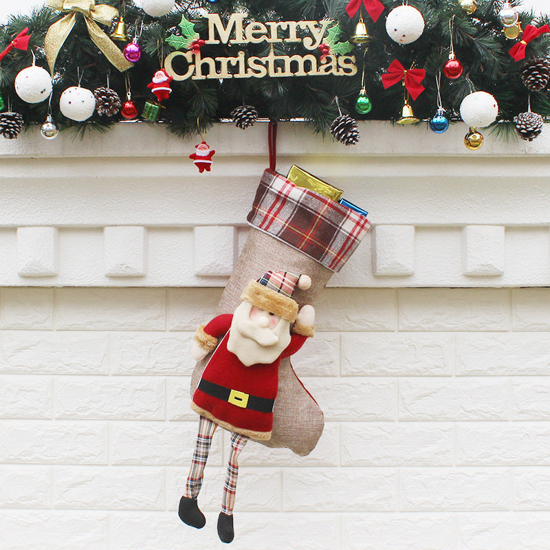 Christmas sock gift bag ornaments filled with small presents, hanging on a decorated Christmas tree