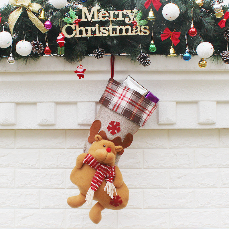 Christmas sock gift bag ornaments filled with small presents, hanging on a decorated Christmas tree