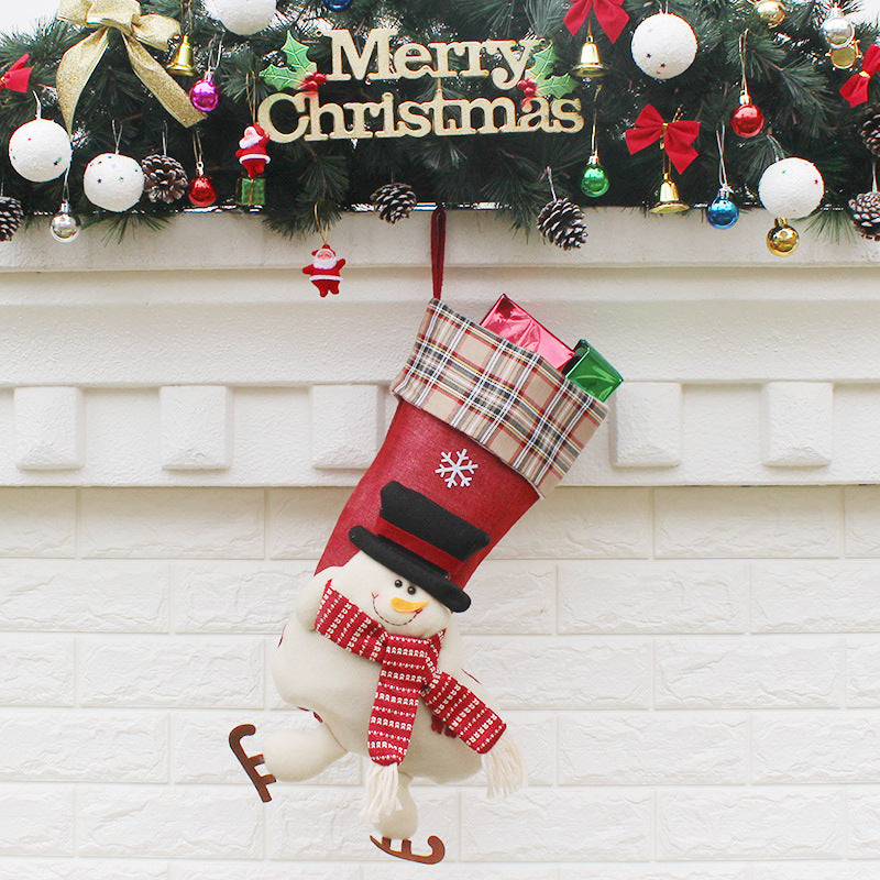 Christmas sock gift bag ornaments filled with small presents, hanging on a decorated Christmas tree