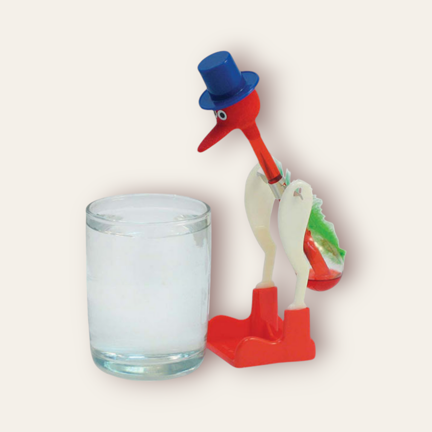 Original Drinking Bird toy featuring a red and white color scheme with a blue top hat. The bird has a clear glass tube body filled with a red liquid, which dips into the beak when activated. The base and head of the bird are red, while the midsection is white, creating a striking contrast. This classic novelty item is both amusing and fascinating to observe as it perpetually ‘drinks’ from a cup when set up properly.