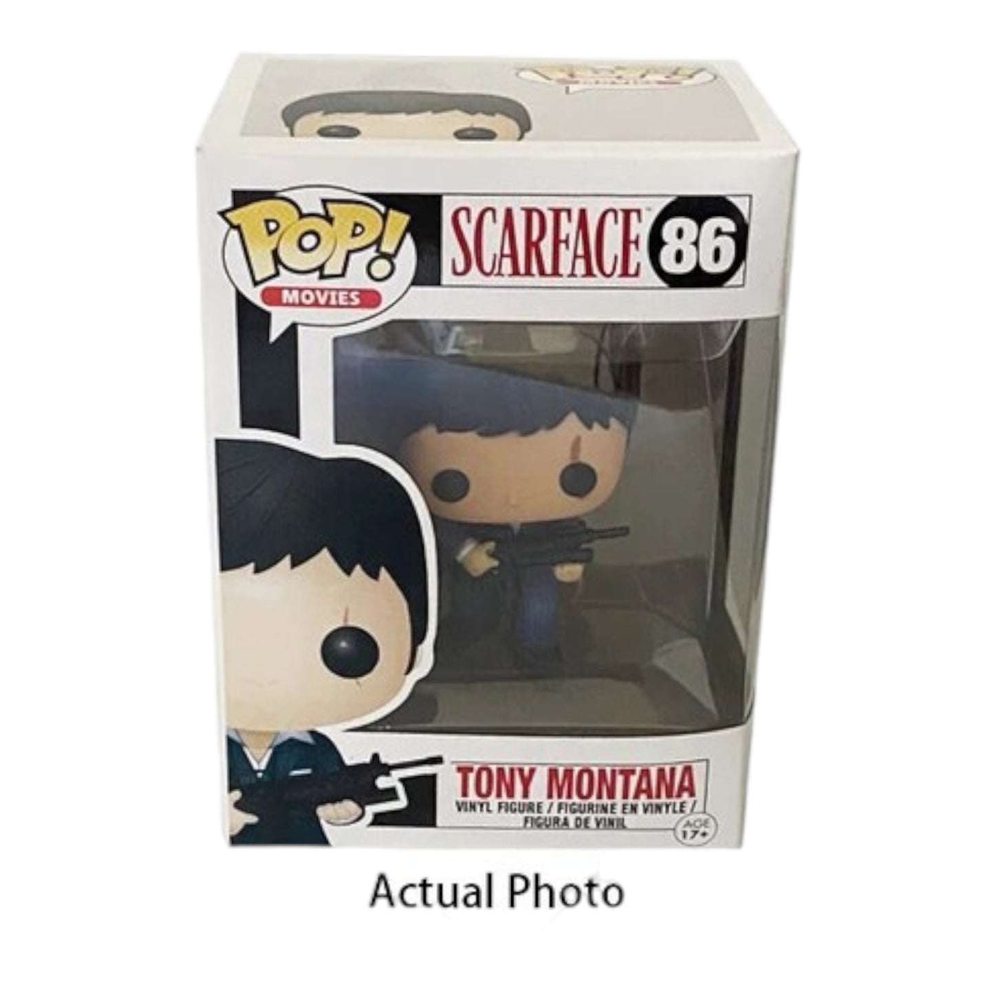 The image shows a Funko Pop! vinyl figure of Tony Montana from the movie "Scarface." The figure is dressed in a blue suit and is holding a rifle. The packaging is also visible, featuring the Pop! Movies logo, the name "Scarface," and the number 86. This collectible is part of the POP Movie Series and is designed for children aged 17 and up. The figure is highly detailed and captures the essence of the iconic character, making it an interesting and relevant item for collectors and fans of the movie.